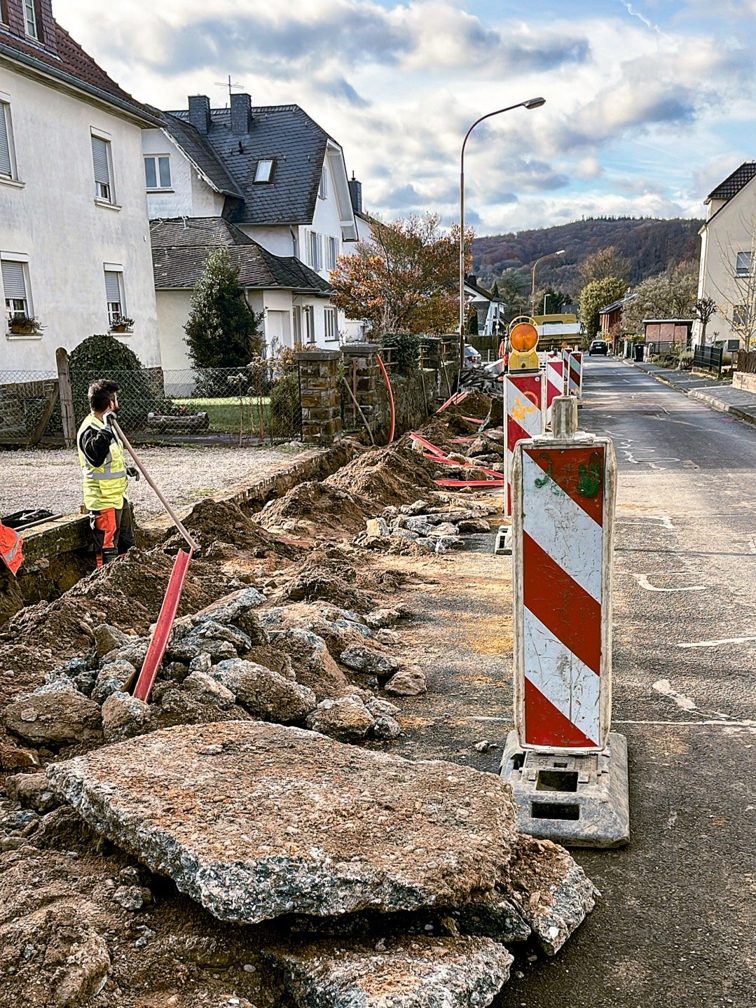 Mann steht in Grabe für Glasfaser in einem Dorf in Deutschland